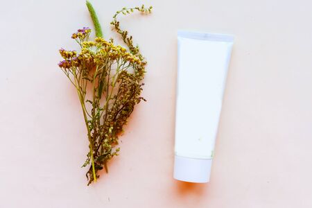 Cream container and herbs on white background, top view, copy space. Natural cosmetic products conceptの写真素材