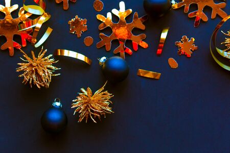 Golden decorations on black background. Flat lay, top view, copy space. Merry Christmas and Happy New Yearの写真素材