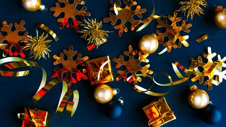 Golden decorations on black background. Flat lay, top view, copy space. Merry Christmas and Happy New Yearの写真素材