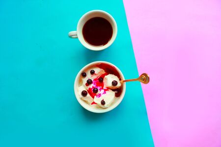 Ice cream in a bowl and coffee cup on geometric blue and pink backgroundの写真素材