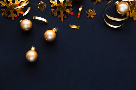 Flat lay photo with Christmas golden decorations on black background. Merry Christmas ans Happy new Year. Top view, copy space. Xmas greeting cardの写真素材