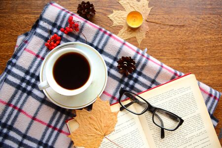 Flat lay photo with coffee cup, glasses and old open book on the tableの写真素材