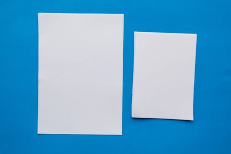 Two white mockup blanks on blue background. Flat lay, top view, copy spaceの写真素材
