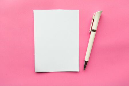 White mockup blank and pen on pink background. Flat lay, top view, copy spaceの写真素材