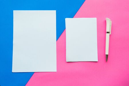 Two white mockup blanks and pen on geometric pink and blue background. Flat lay, top view, copy spaceの写真素材