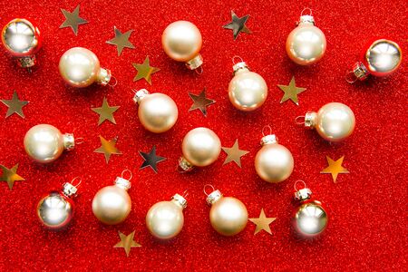 Golden Christmas baubles on bright red glitter backgroundの写真素材