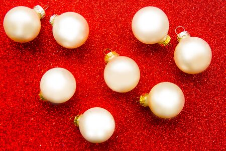 white Christmas baubles on bright red backgroundの写真素材