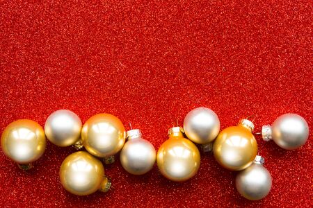 Christmas baubles on bright red glitter background, copy spaceの写真素材