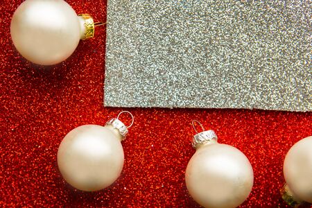 Christmas white baubles on bright red and silver background backgroundの写真素材