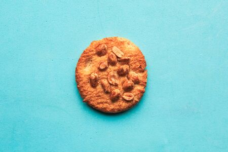 Tasty round cookies with nuts on blue background, top view, minimalの写真素材