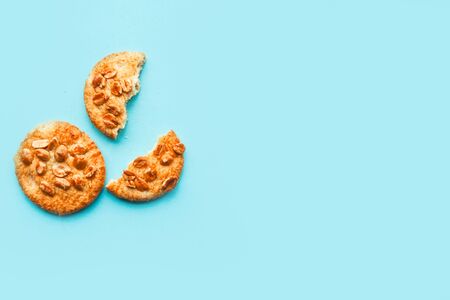 Tasty round cookies with nuts on blue background, top view, copy spaceの写真素材