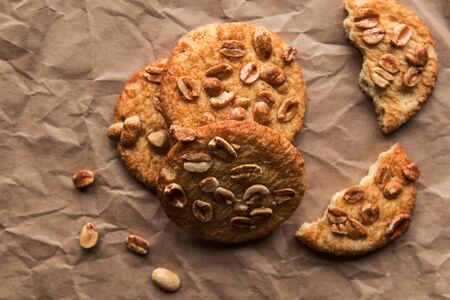 Tasty round cookies with nuts on crumble paperの写真素材