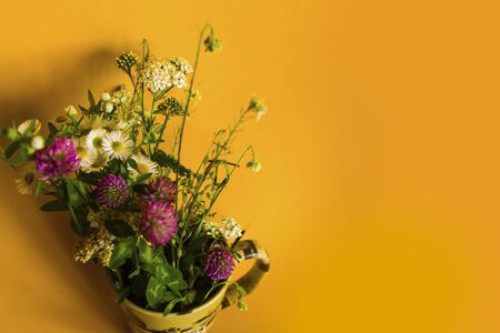 bouquet of summer flowers on yellow backgroundの写真素材