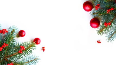 Natural spruce branches with red baubles on white background. Flat lay, top view, copy space. Beautiful Christmas greeting cardの写真素材