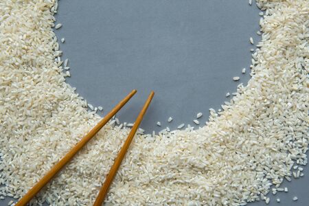 Round frame from dry white rice on gray background. Flat lay, top view, copy spaceの写真素材