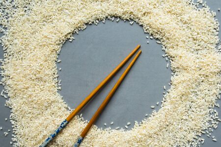 Round frame from dry white rice on gray background. Flat lay, top view, copy spaceの写真素材