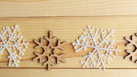 White and wooden snoflakes on wooden background. Christmas abstract backgroundの写真素材