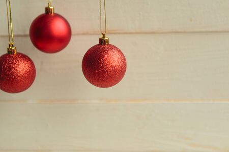 Three red Christmas balls, wooden background. Copy space. Christmas greeting cardの写真素材