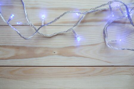 Christmas lights bulb decoration on old wood plank. Merry Christmas and New Year holiday background.の写真素材