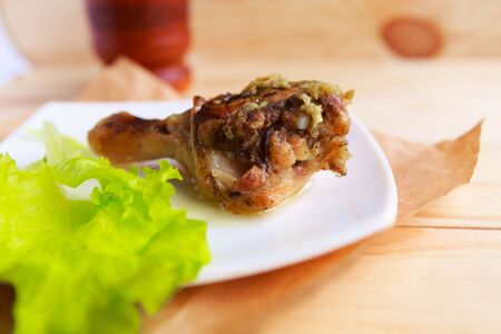 fried chicken leg on white plate served with saladの写真素材