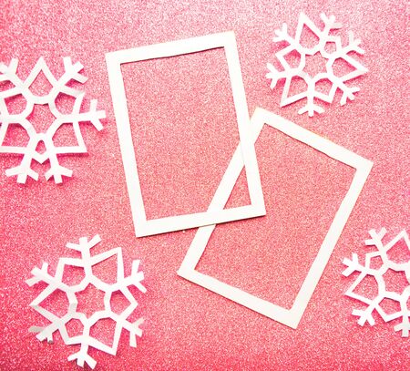 Photo frame decorative with snowflakes on pink glitter background. Copy space for the textの写真素材