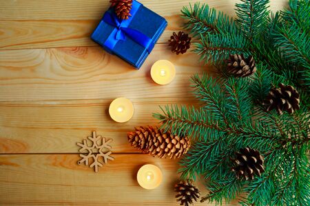 Christmas composition - gift b?x, spruce branches and candles on wooden background. Flat lay, top viewの写真素材