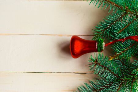 Christmas tree branches and vintage red jingle bell on wooden background. Flat lay, top view, copy spaceの写真素材