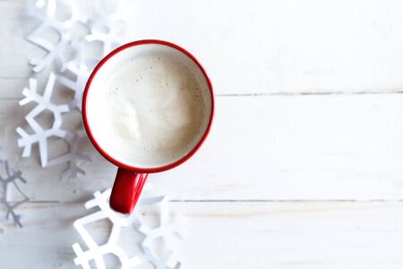 Coffee cup with milk and Christmas decorations on white wooden background. Flat lay, top view, copy spaceの写真素材
