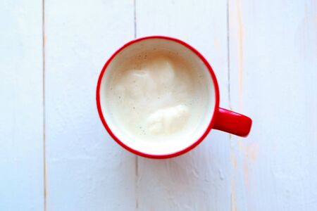 Coffee cup with milk on white wooden background. の写真素材