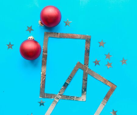 Silver photo frame and Christmas baubles on bright blue background. Xmas greeting cardの写真素材