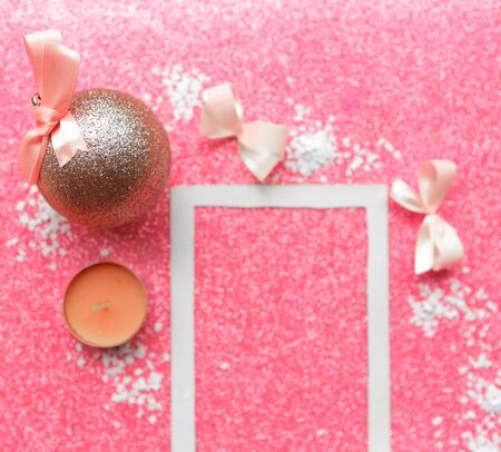 Christmas composition. Photo frame and Christmas decorations on pink glitter background. Christmas, winter, new year concept. Flat lay, top view, copy spaceの写真素材