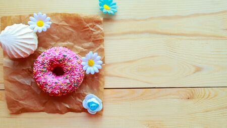 White zefir and pink donut on wooden table, top view. Copy space for the textの写真素材
