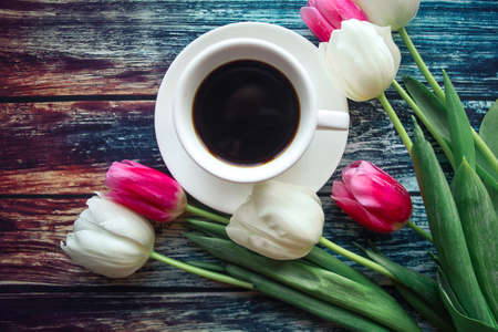 Coffee cup and tulips on wooden backgroundの写真素材