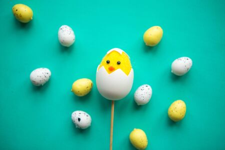 toy chicken in shell and quail eggs on green background. Easter greeting cardの写真素材