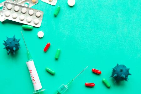 Disposable syringes and pills on green background.  Coronavirus disease covid-19の写真素材