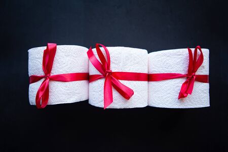 toilet paper rolls wrapped in gift bow on black background. Covid19 conceptの写真素材