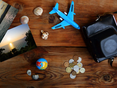 Summer vacation concept - flatlay photo with toy airplane and money on wooden background