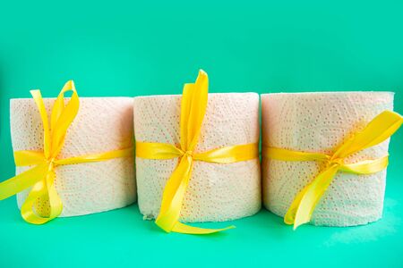 toilet paper rolls wrapped in gift bows on green background. Covid19 concept.の写真素材