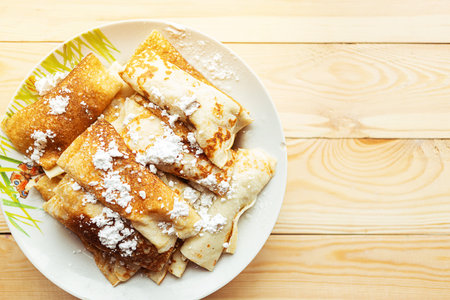 Tasty pancake rolls, top view, wooden background