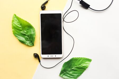 Mobile phone with black mockup screen and coffee cup on yellow background. Minimal concept
の写真素材