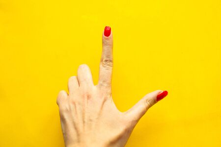 Woman's hand shows the point gesture over bright yellow background. Minimal concept. Copy space for the text
の写真素材