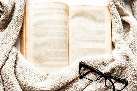 Old open book, glasses and sweater, top viewの写真素材