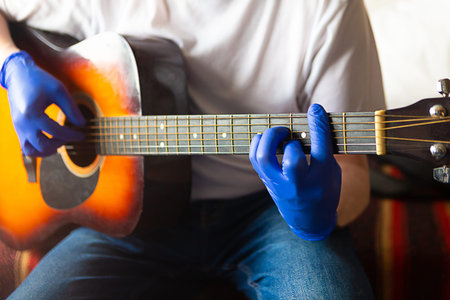Man in medical gloves plays the guitar. Coronavirus quarantine concept
