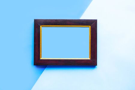 Wooden photo frame on geometric blue background. Copy space for the textの写真素材