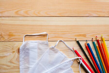 Color pencils and medical masks on wooden table. Back to school concept. School quarantine conceptの写真素材