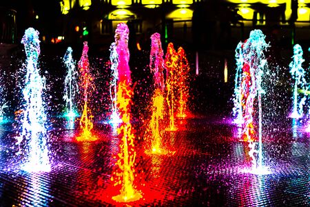 Bright and colorful fountain at night streetの写真素材