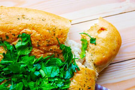 Fresh tasty home baked loaf of bread with parsley on wooden backgroundの写真素材