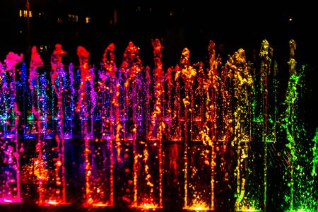 Bright and colorful fountain at night streetの写真素材