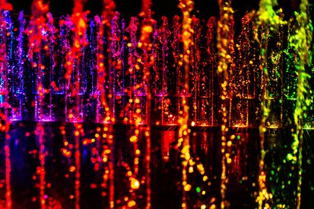 Bright and colorful fountain at night streetの写真素材