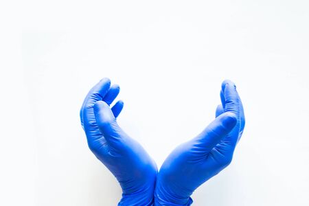 Hands in blue medical gloves showing a gesture of save. White background, copy space for the textの写真素材